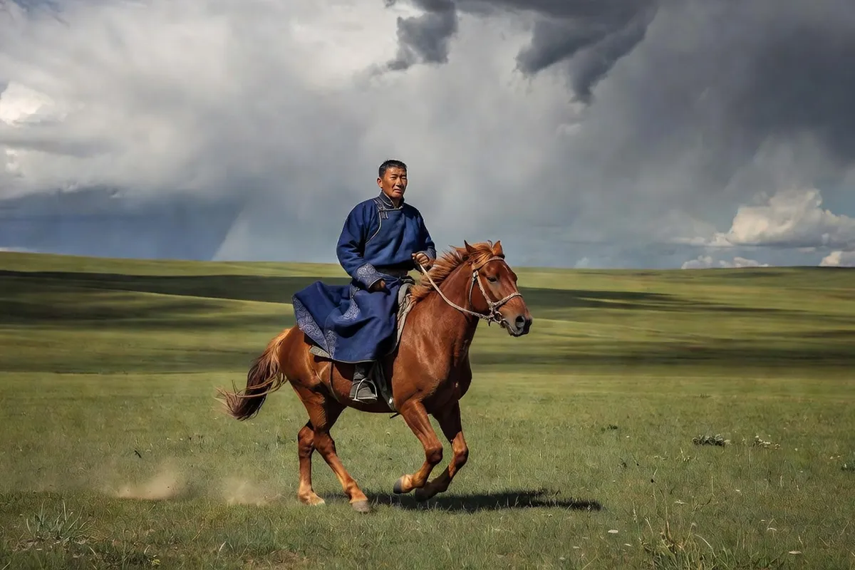 Cavalier mongol traversant la steppe à cheval au coucher du soleil